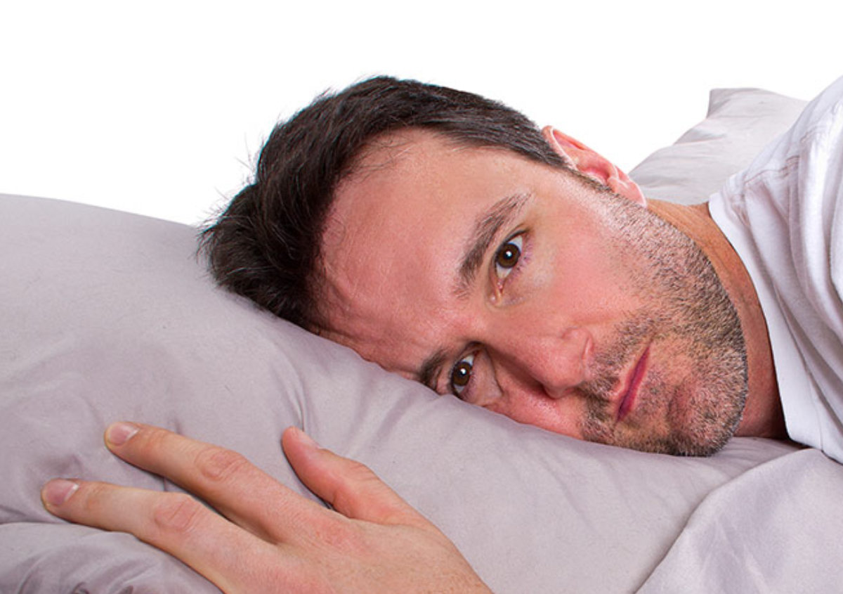 Man suffering from insomnia in bed